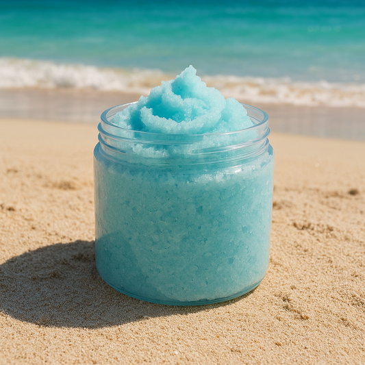 Jar of blue sugar scrub on a sandy beach with ocean and sky in the background